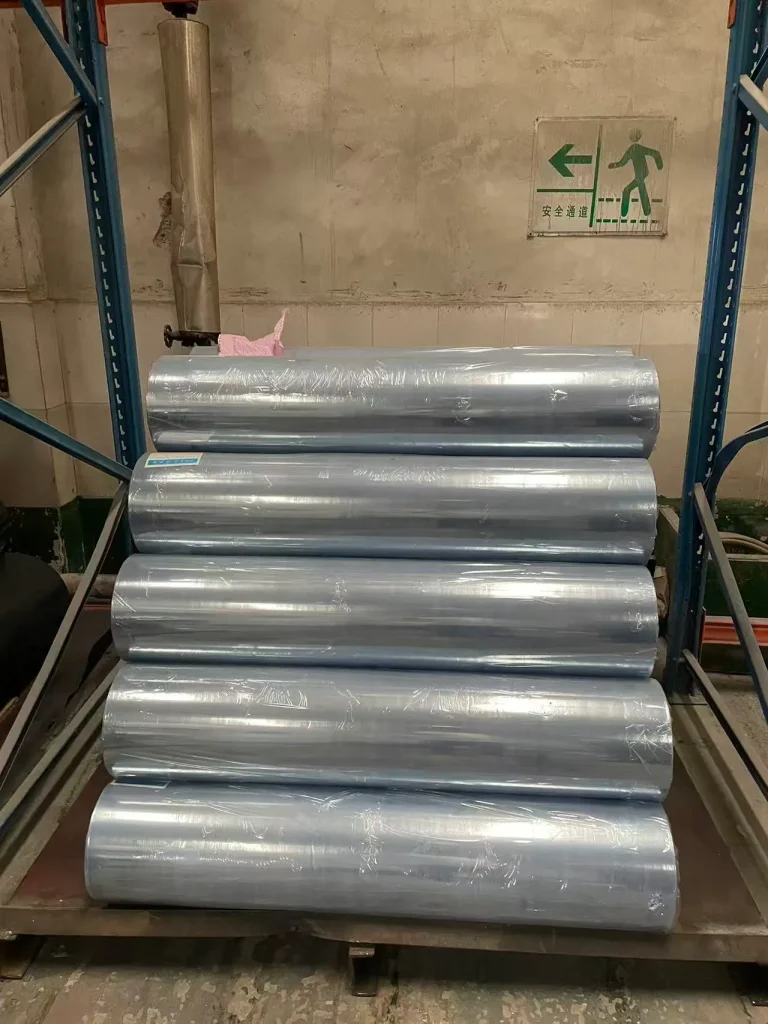 Clear lamination embossing film rolls with a distinctive blue protective tint in factory storage, displaying high-volume wholesale capacity